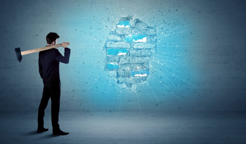 Business man hitting grungy brick wall with huge hammer